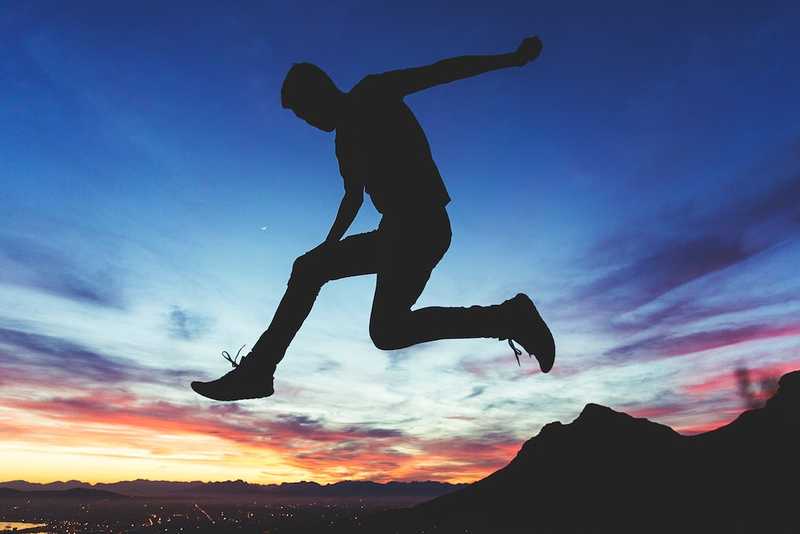 Sillhouette of a Man Jumping near a Mountain